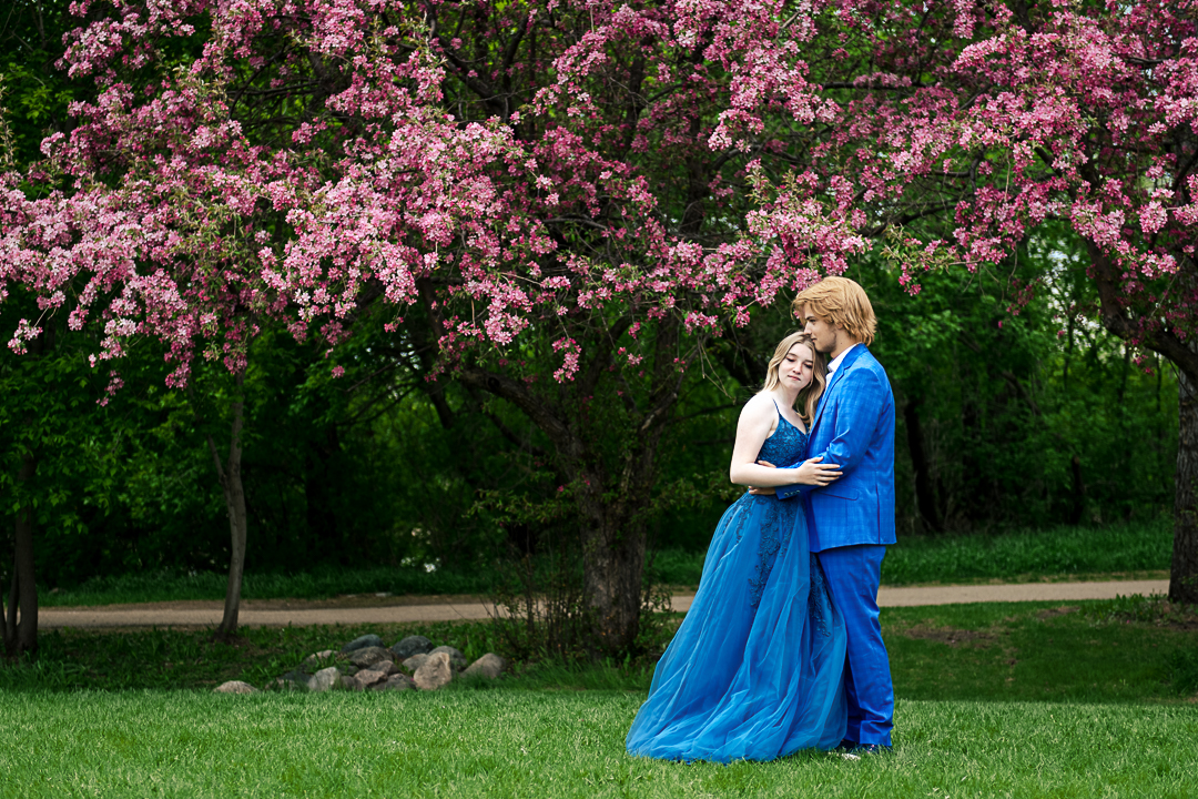 Graduation Portraits with a couple in blue under cherry blossom trees
