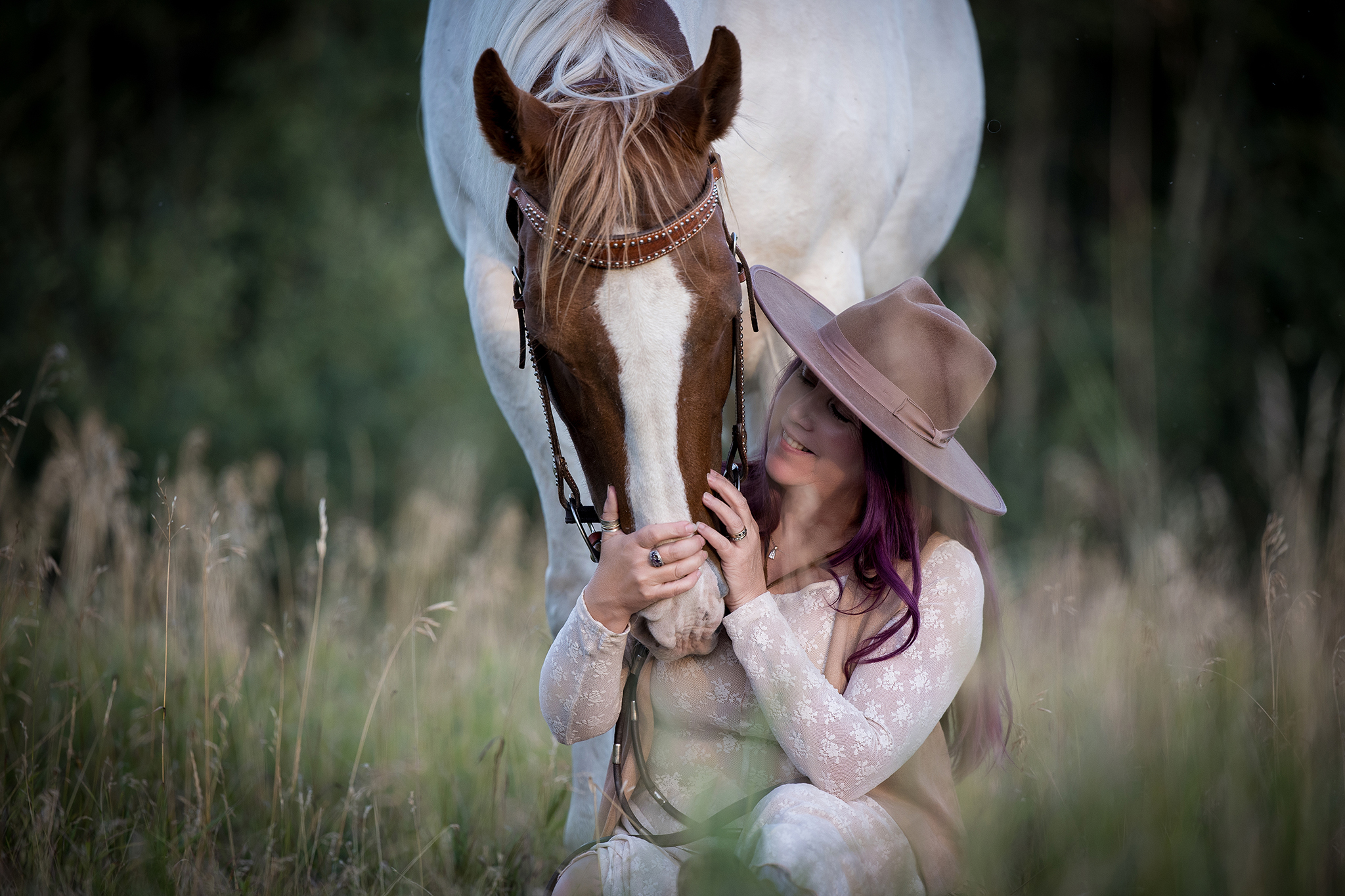 A heartfelt image of a woman sitting in a peaceful meadow with her paint horse, Chicka. The woman gently leans toward Chicka, sharing a quiet moment of connection and tenderness, surrounded by lush greenery and wildflowers. The bond between them radiates love and trust, set against the serenity of the natural setting.