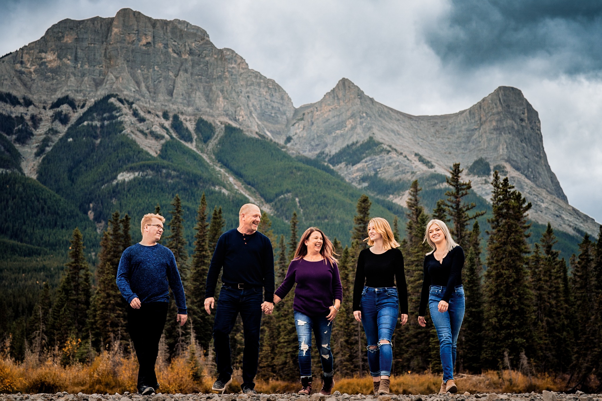Family portrait - a family walking with the Canmore mountains behind them